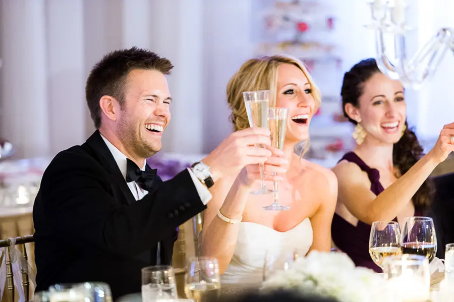 A man and woman holding champagne glasses at a wedding.