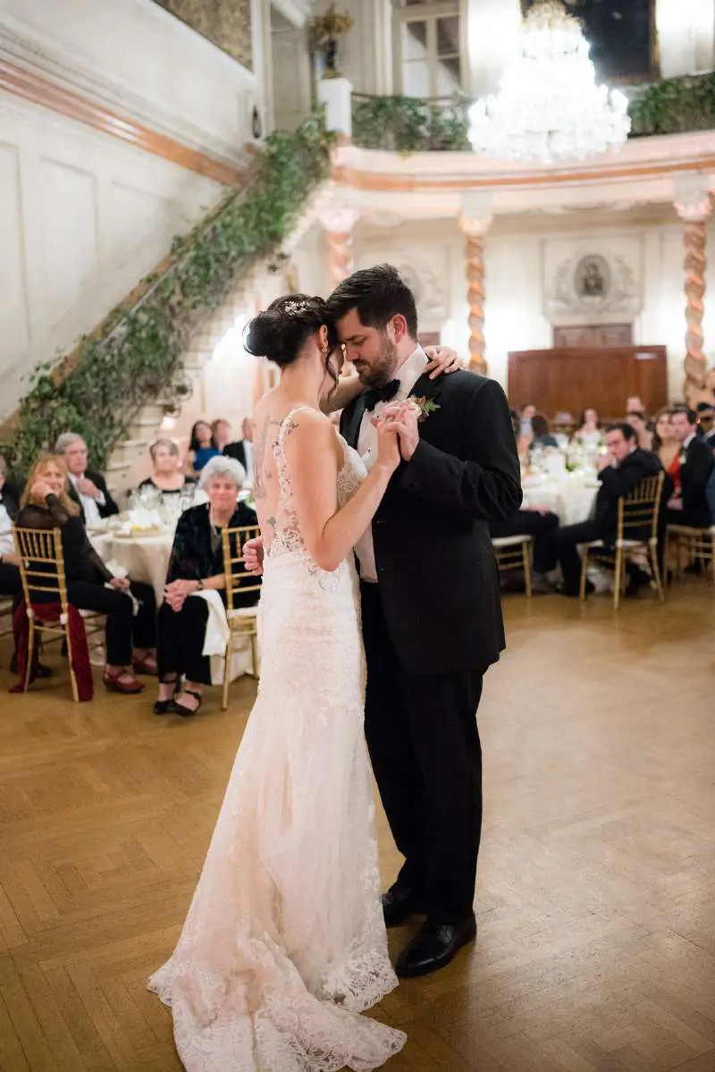 A bride and groom dance in front of an audience.