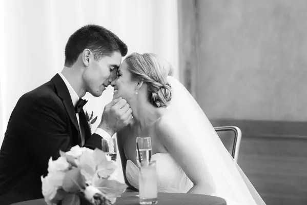 A man and woman sitting at a table with champagne.