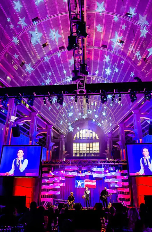 A stage with lights and two large screens